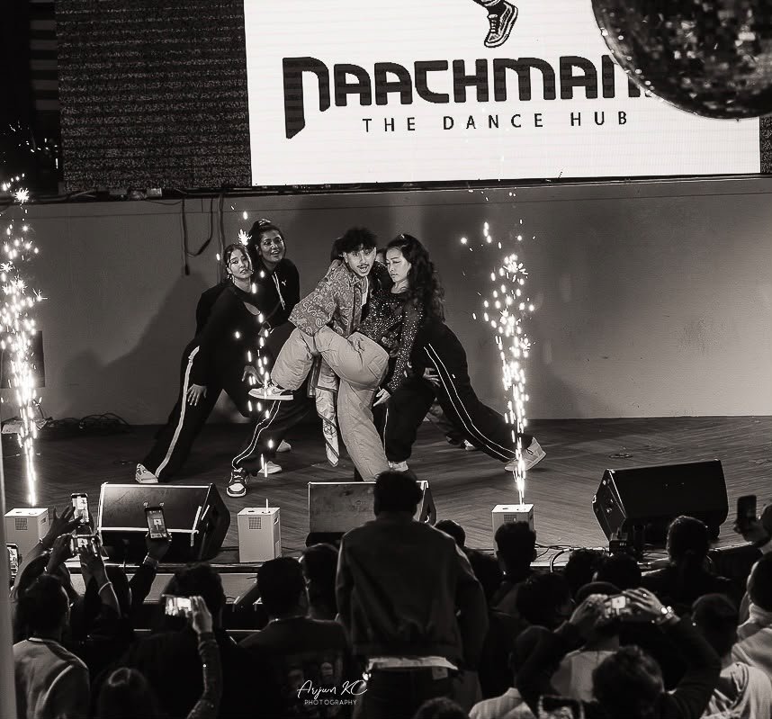 Naachmandu dancers performing live on stage with sparklers and a cheering crowd